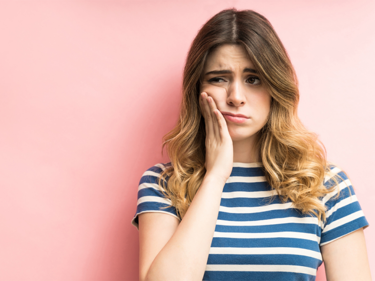 image of a girl holding her cheek in pain