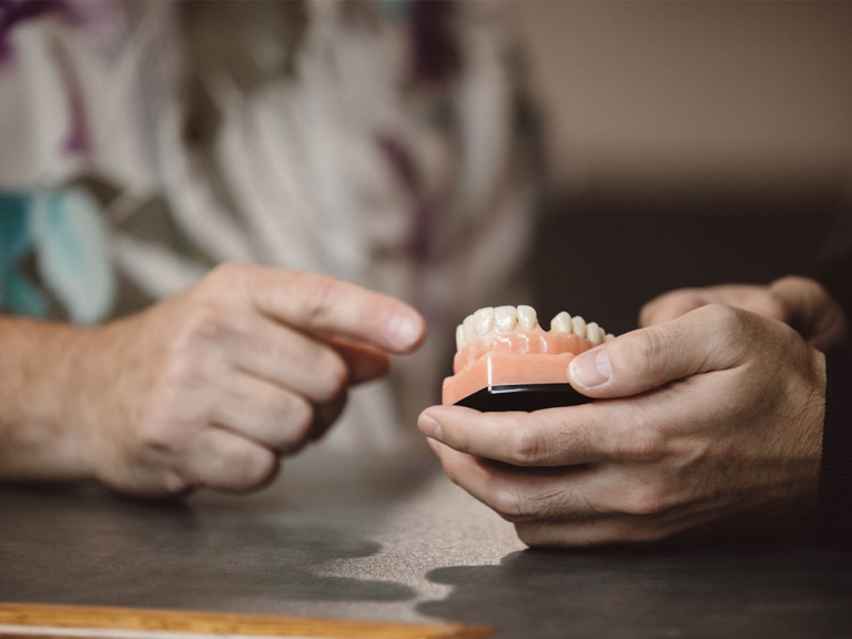 image of hands holding a pair of fake teeth