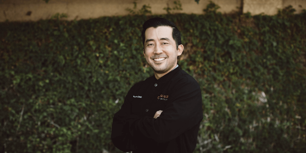 The image showcases a professional, wearing a black dental jacket embroidered with 