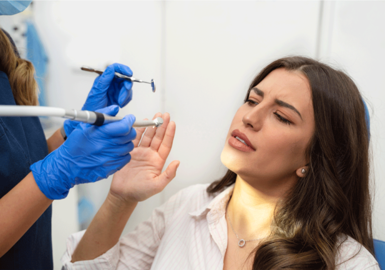 a girl holding her hand up to dental tools to stop dental hygienists